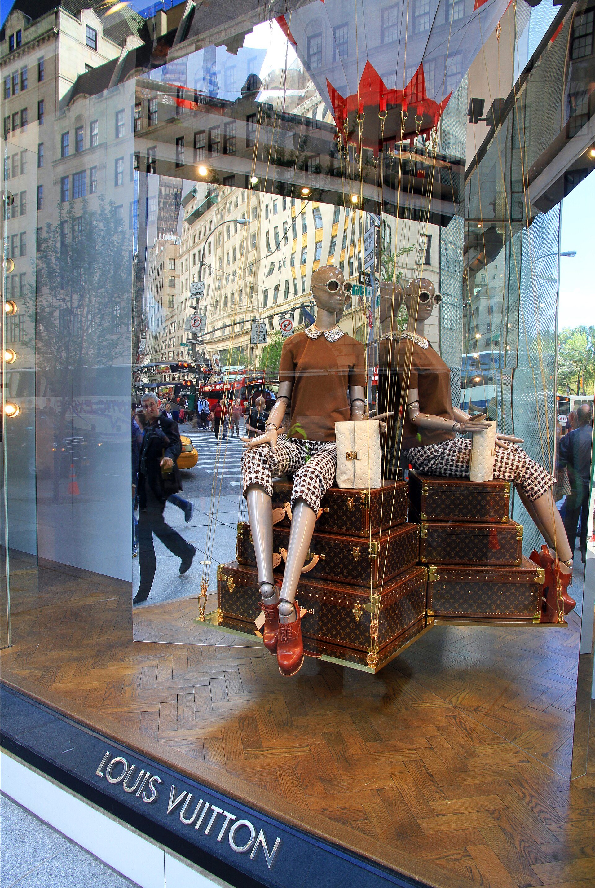 Vitrine da Louis Vuitton na 5th Avenue em Nova York com manequins sobre baús estampados no icônico Monogram LV, criado em 1896