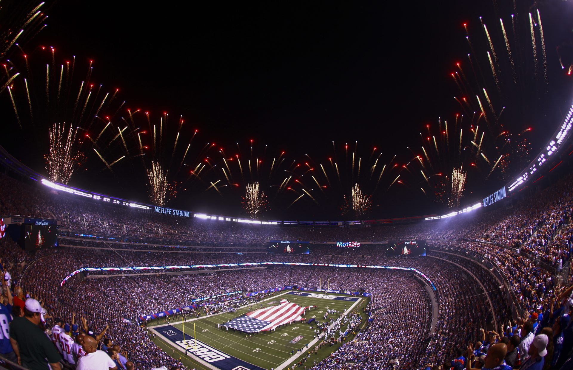 MetLife Stadium lotado durante evento noturno com fogos de artifício