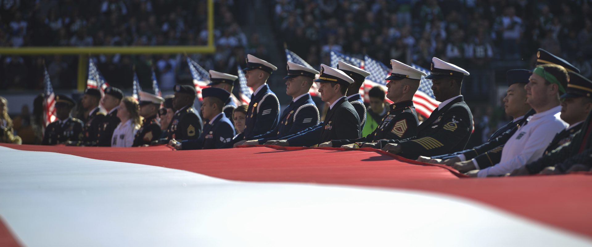 Cerimônia com bandeira americana no MetLife Stadium com militares