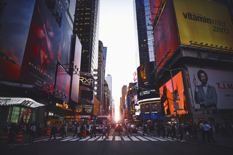 Times Square iluminada à noite em Nova York com seus letreiros luminosos e restaurantes